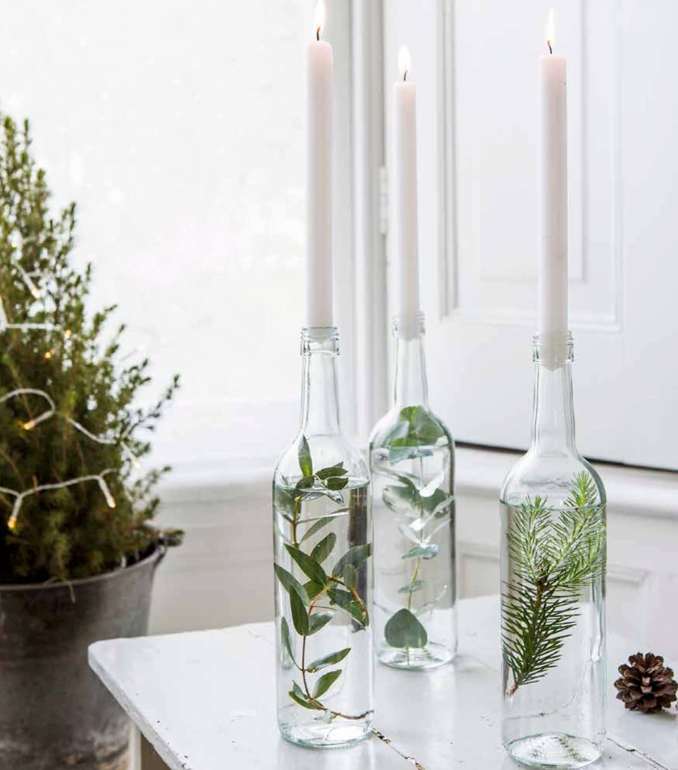 Candlesticks with bottles and fir branches.