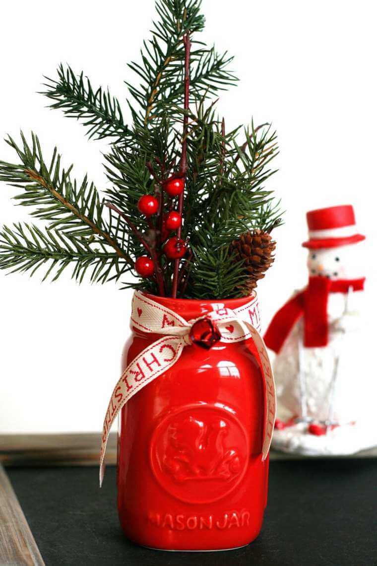 Christmas composition with fir branches placed in a red jar 
