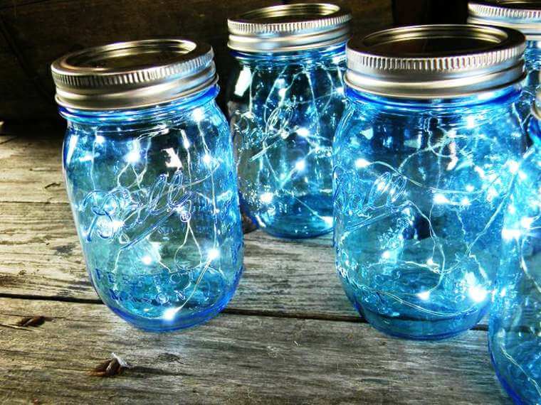 Glass jars with light garlands placed inside 