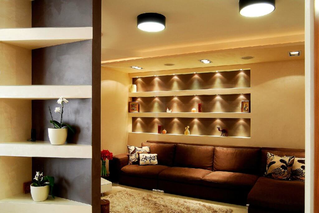 beige wall with niches, brown fabric sofa and matching cushions with patterns (1)