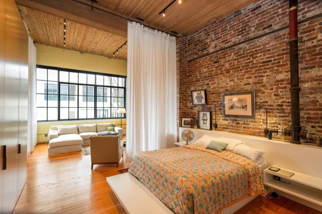 Bedroom in an industrial space with wooden ceiling and red brick (1)